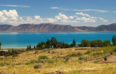 An aerial view of Bear Lake showing blue water and mountains in the distance near Soda Creek Campground in Soda Springs, Idaho.